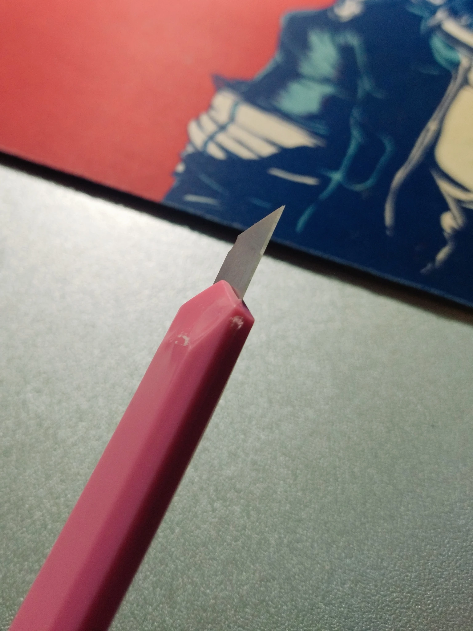 Foto del retro-destro del taglierino, si nota un po' di ruvidume sul bordo, segno della scarsa plastica, e si notano alcuni riflessi della trama