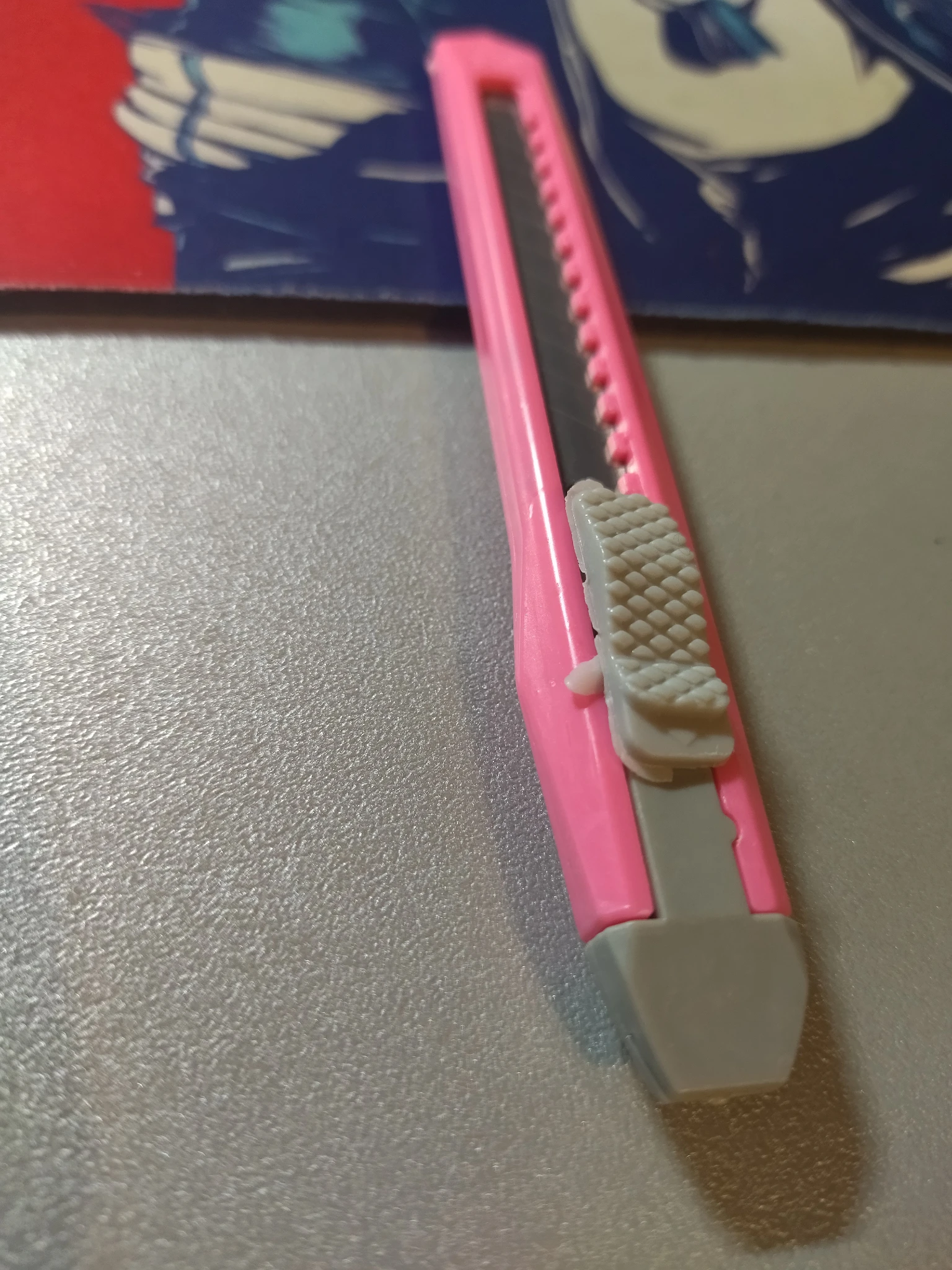 Foto del lato sinistro-fronte del taglierino, si nota il coso per scorrere che ha varie di quelle classiche pellicine di plastica