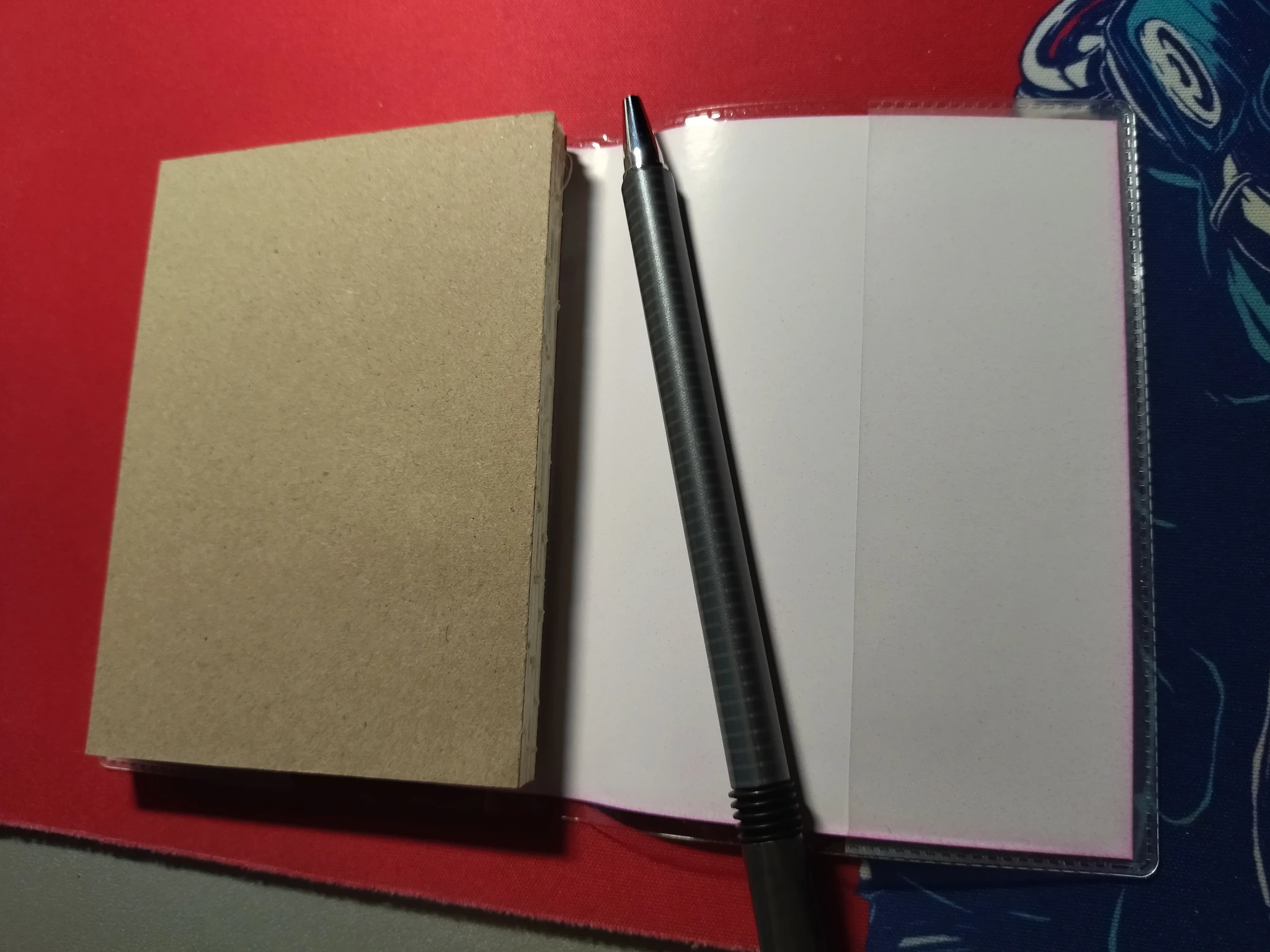 Foto del quaderno con la parte interna estratta da un lato, si vede l'interno della copertina esterna con dentro la copertina interna, e si nota la parte esterna di cartone del blocco interno.