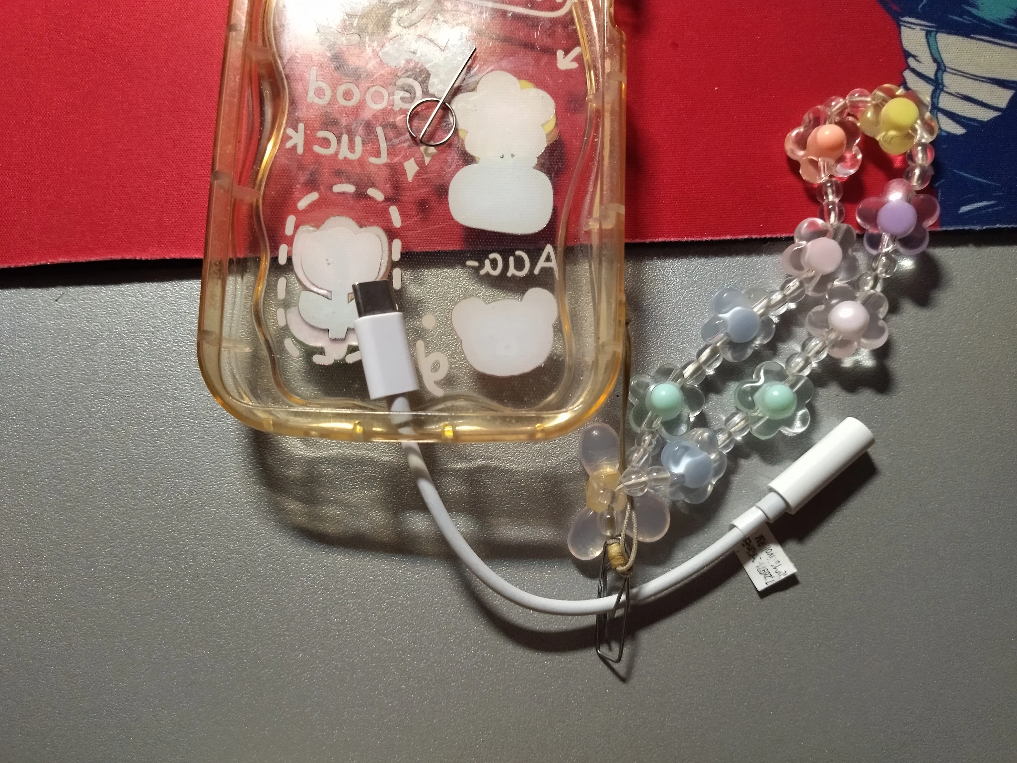 Foto della mia cover senza telefono con il suo laccetto e l'adattatore USB agganciato come descritto