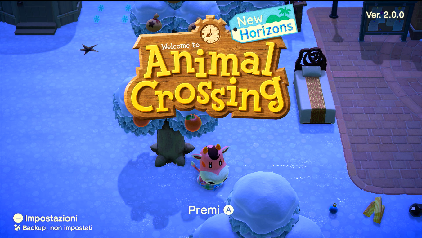 Schermata del titolo di Animal Crossing New Horizons, si vede un angolo della piazza con vari oggetti a terra, e l'angolo di una casa con vari fiocchi di neve a terra