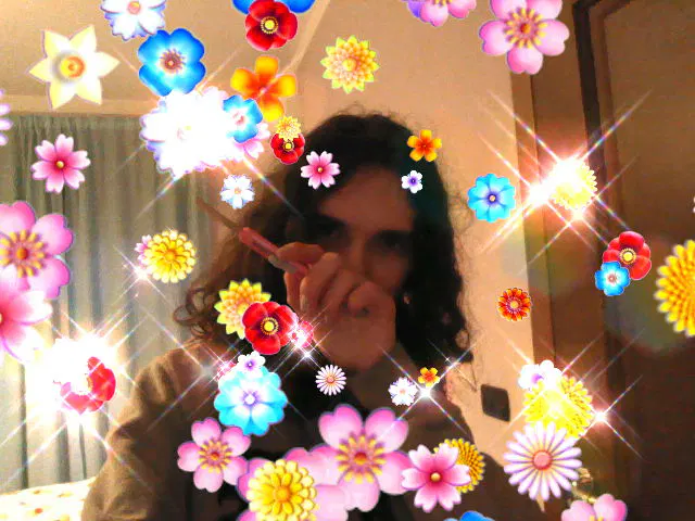 Selfie con modalità Festa del 3DS, molti fiori, con io che ho in mano il taglierino mezzo aperto mentre con la mano mi copro metà faccia